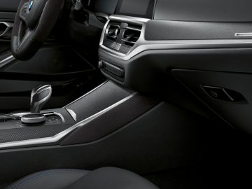 Modern BMW 4 Serie Coupé-interieur met lederen stoelen, automatische versnellingspook en bedieningselementen op de middenconsole.