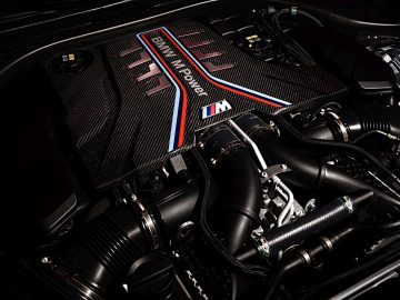 Close-up van een BMW M5-motor met koolstofvezelcomponenten.