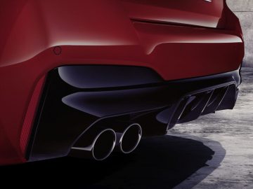 Close-up van de achterste uitlaat en diffuser van een rode BMW M5.