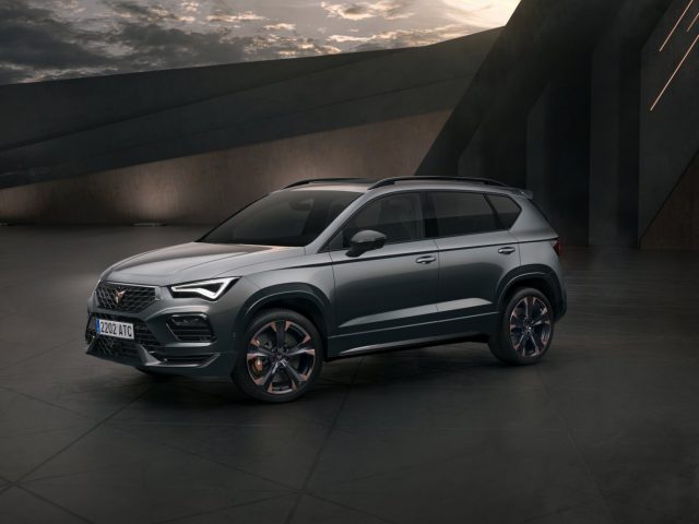 Een moderne Cupra Ateca SUV geparkeerd in een architectonische omgeving met dramatische verlichting.