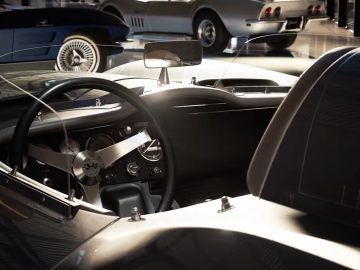 Binnenaanzicht van een klassieke sportwagen met de nadruk op het stuur en het dashboard, met luxe design en vintage stijl, die doet denken aan Gran Turismo 7 van PlayStation 5.