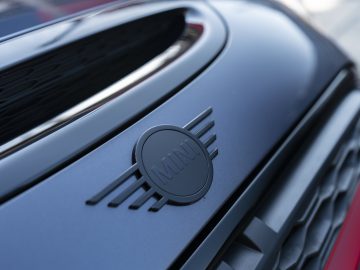 Close-up van een MINI John Cooper Works GP 2020 auto-embleem op de grille van een voertuig.