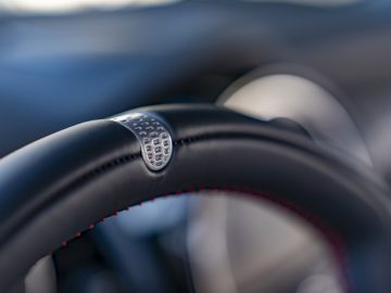 Close-up van een MINI John Cooper Works GP 2020 autostuur met rode stiksels en getextureerd gripdetail.