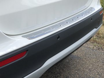 Achterbumper van een witte Mercedes-Benz GLA met een beschermende metalen dorpellijst.