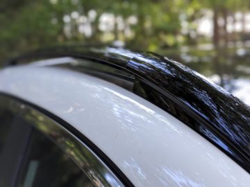 Close-up van het dak van een Nissan Qashqai N-TEC met focus op de rand van de achterruit en het weerstrippen ervan.