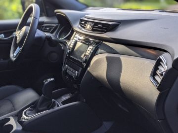 Binnenaanzicht van een Nissan Qashqai N-TEC met het dashboard, het infotainmentsysteem en de middenconsole.