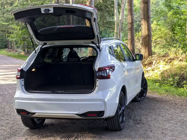 Witte Nissan Qashqai N-TEC SUV geparkeerd op een bosweg met de hatchback open.