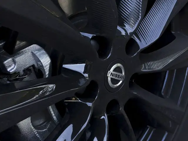 Close-up van een zwart Nissan Qashqai N-TEC autowiel met gedetailleerd zicht op de velgspaken en het merklogo.