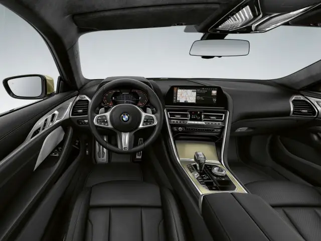 Binnenaanzicht van een BMW 8 Serie-voertuig met het stuur, het dashboard, het infotainmentsysteem en de middenconsole.