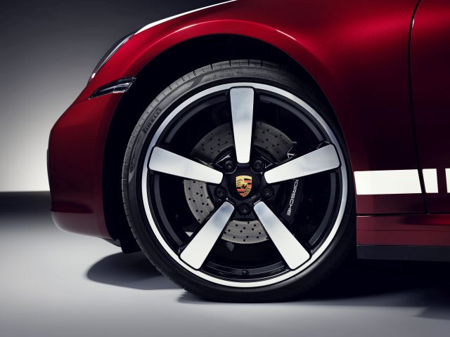 Close-up van een rood Porsche 911 Targa 4S Heritage Design Edition-wiel met schijfremmen en lichtmetalen velg.