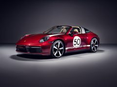 Rode Porsche 911 Targa 4S Heritage Design Edition sportwagen met nummer 50 op de zijkant, tentoongesteld onder een spotlight.