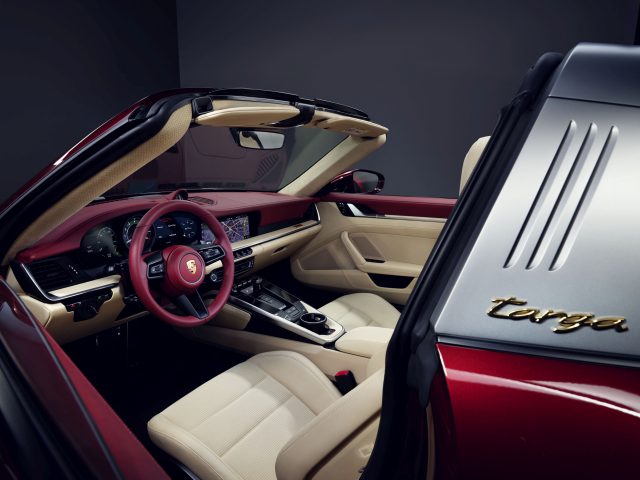 Binnenaanzicht van een Porsche 911 Targa 4S Heritage Design Edition met crème lederen stoelen en een rood stuur.