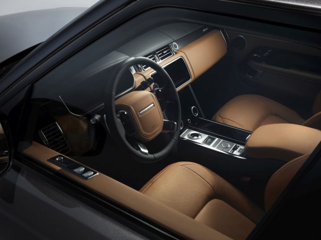Luxe Range Rover Fifty interieur met lederen stoelen en modern dashboard.