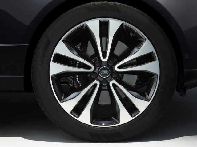 Close-up van een lichtmetalen velg van een Range Rover Fifty met een zwarte en metallic afwerking.