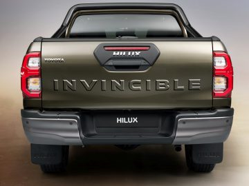 Achteraanzicht van een Toyota Hilux pick-up met "onoverwinnelijk" op de achterklep geschreven.