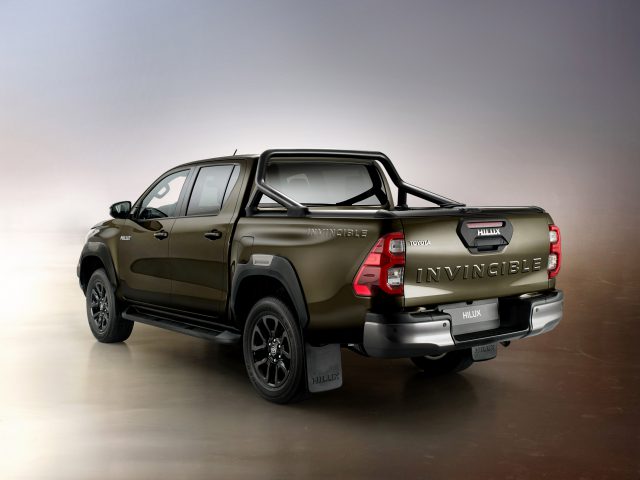 Een Toyota Hilux pick-up truck tentoongesteld tegen een achtergrond met kleurovergang.