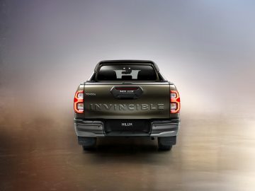 Toyota Hilux pick-up truck van achteren gezien tegen een achtergrond met kleurovergang.