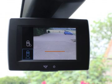 Het display van de achteruitkijkcamera van een voertuig toont een duidelijke parkeerplaats met in de verte een enkele blauwe Toyota PROACE City.
