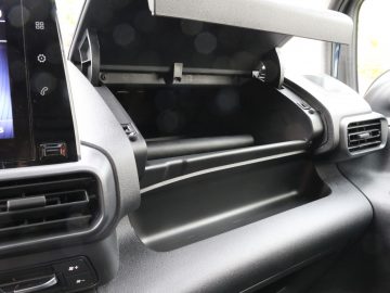 Binnenaanzicht van een Toyota PROACE City met een open dashboardkastje met daarboven een ingebouwd scherm.