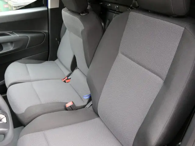 Toyota PROACE City met stof beklede autostoelen vooraan met veiligheidsgordels.