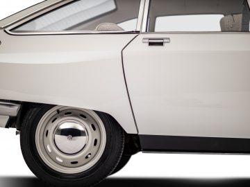 Close-up van het achterpaneel en het stuur van een witte Citroën C4 tegen een witte achtergrond.