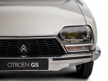 Close-up van een witte Citroën C4, gericht op de grille en de koplamp.