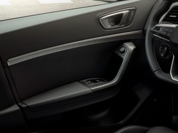 Binnenaanzicht van een autodeur van Seat Ateca met lederen bekleding en bedieningselementen.