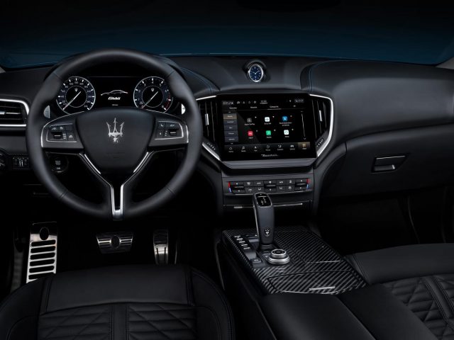 Binnenaanzicht van een Maserati Ghibli Hybrid met de nadruk op het stuur, het dashboard en de middenconsole met hoogwaardige afwerking en digitale displays.