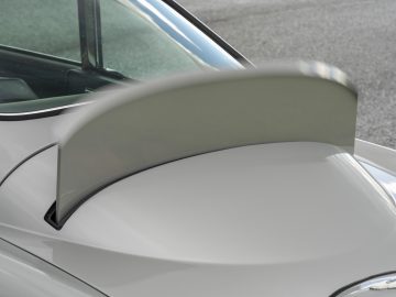 Close-up van de achterspoiler van de Aston Martin DB5 Goldfinger Continuation, gemonteerd op de kofferbak, waarbij de vloeiende ronding en ontwerpdetails goed zichtbaar zijn.