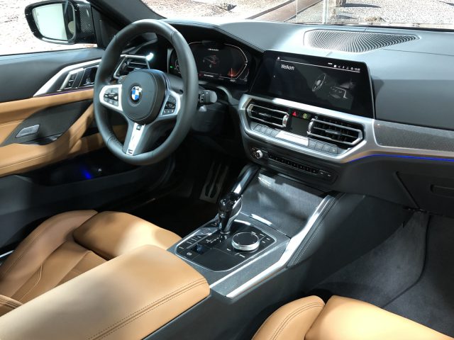 Interieur van een BMW 4 Serie Coupé met bruin lederen stoelen, een middenconsole, stuur en een digitaal display.
