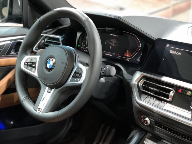 Binnenaanzicht van een BMW 4 Serie Coupé met het stuur, het dashboard en het infotainmentscherm.