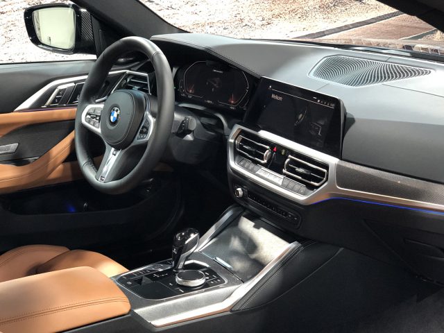 Interieur van een BMW 4 Serie Coupé, met een stuur, dashboard met digitale displays en lederen stoelen.