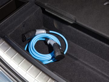 Een oplaadkabel voor elektrische auto's netjes opgerold in de kofferbak van een BMW X1.