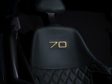 Zwarte autostoel met diamantstiksel en het nummer '70' in geel geborduurd op de hoofdsteun, afkomstig van de Donkervoort D8 GTO-JD70 Bare Naked Carbon Edition.