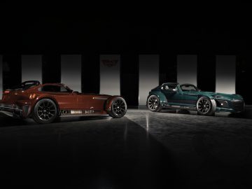 Twee luxe sportwagens, een coupé en een Donkervoort D8 GTO-JD70 Bare Naked Carbon Edition cabriolet, naast elkaar geparkeerd in een slecht verlichte ruimte, met strakke ontwerpen