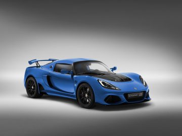 Blauwe Lotus Exige sportwagen op een grijze achtergrond met studioverlichting.