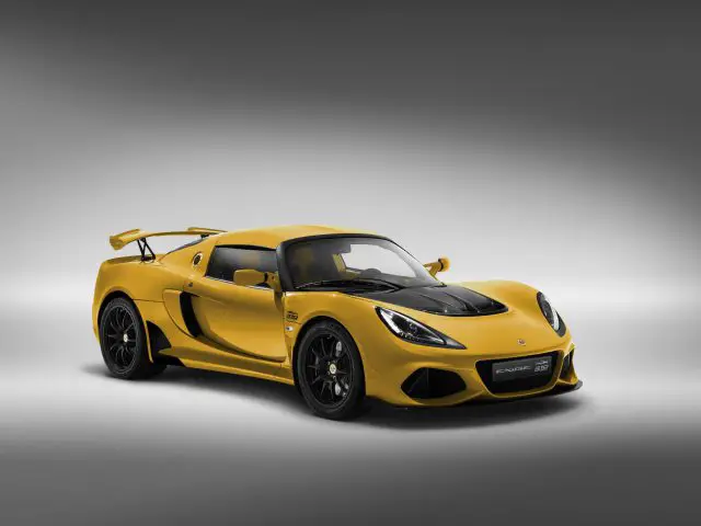 Gele Lotus Exige sportwagen op een grijze achtergrond.