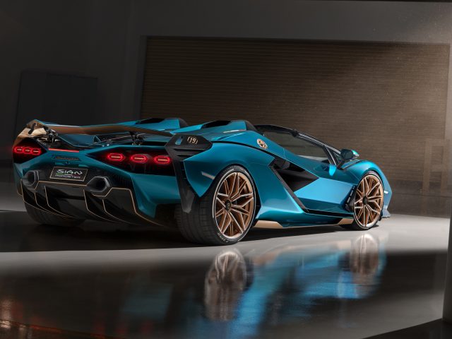 Een blauwe Lamborghini Sián Roadster, een hybride sportwagen, geparkeerd in een strakke showroom met dramatische verlichting.
