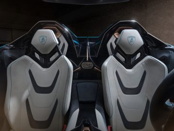 Binnenaanzicht van een Lamborghini Sián Roadster met twee luxe stoelen met lederen bekleding en verlichte blauwe accenten.