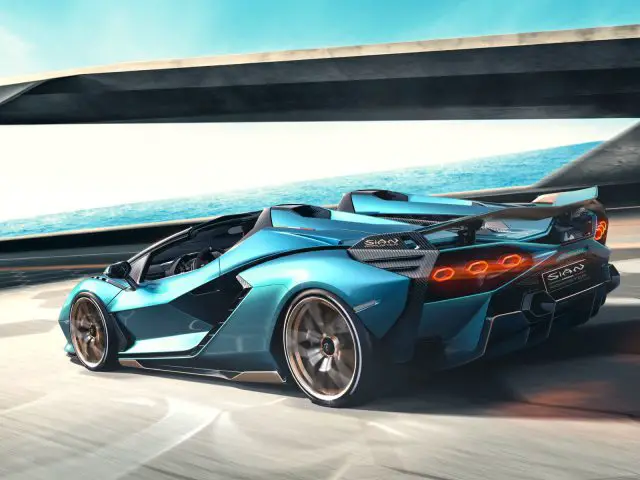 Een blauwe Lamborghini Sián Roadster rijdt op een snelweg met een onscherpe achtergrond die de nadruk legt op hoge snelheid.