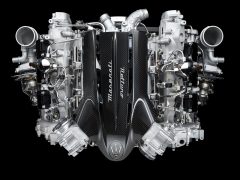 Een Maserati Nettuno V8-motor geïsoleerd op een zwarte achtergrond.