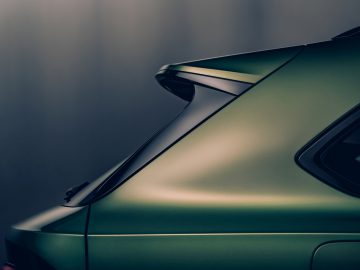 Close-up van de achterkant van een groene Bentley Bentayga, waarbij de spoiler en het strakke ontwerp benadrukt worden.