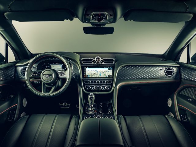 Binnenaanzicht van een Bentley Bentayga met leren stoelen, een stuur met bedieningselementen, centraal touchscreen en automatische versnellingspook.
