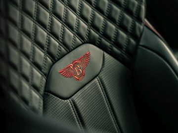 Luxe Bentley Bentayga-interieur met close-up van leren stoelstiksels en embleem.
