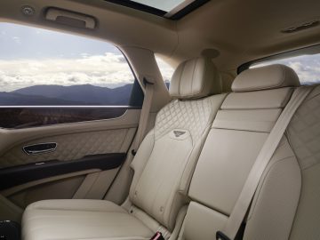 Luxe Bentley Bentayga-interieur met lederen stoelen met diamantstiksel en een panoramisch zonnedak.