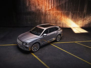 Luxe Bentley Bentayga SUV geparkeerd in een industriële omgeving met dramatische verlichting.