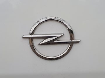Zilver Opel Vivaro-logo op een witte autoachtergrond.