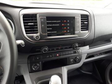 Opel Vivaro-dashboard met een multimediasysteemdisplay en ventilatieopeningen, met daaronder klimaatregelaars.