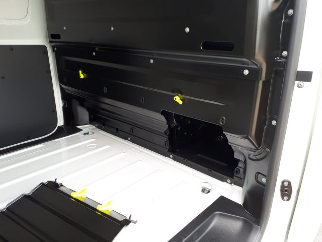 Binnenaanzicht van een lege laadruimte van een Opel Vivaro-bestelwagen met zichtbare metalen wanden en vloer met zichtbare verankeringspunten.