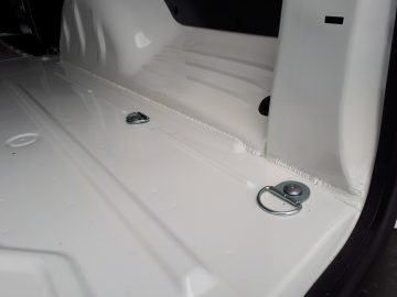 Close-up van het interieur van de kofferbak van de Opel Vivaro, met het grendelmechanisme en een kitrups die langs een verbinding is aangebracht.